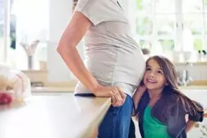 Girl listening to pregnant mother√É¬≠s belly