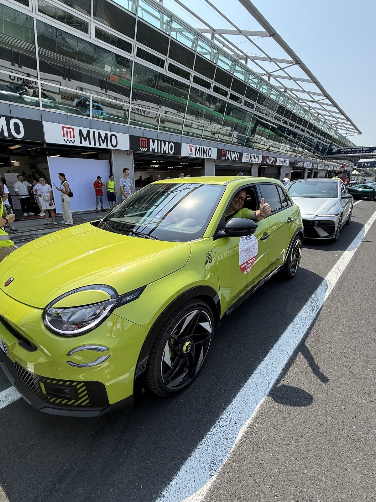 L'Abarth 600e Scorpionissima verde acido schierata per la MIMO Parade 2026 davanti ai box dell'Autodromo Nazionale Monza